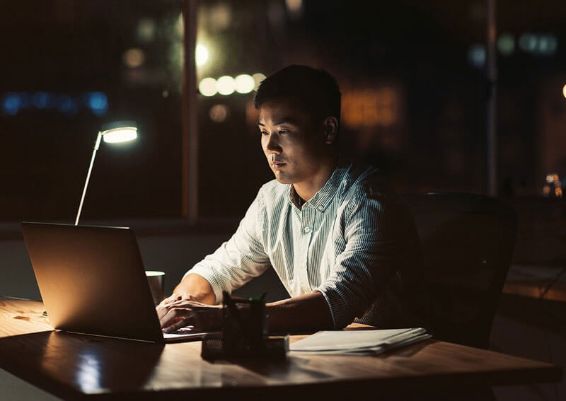 Man working on computer in dark