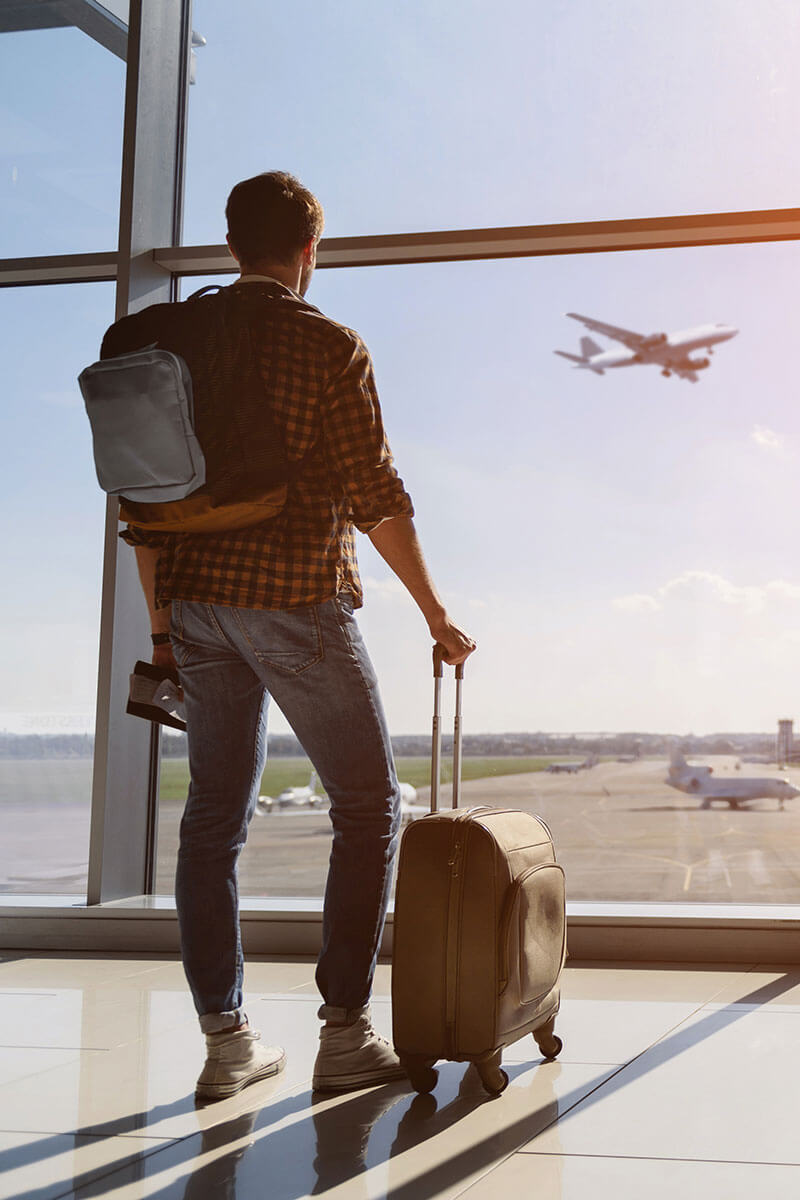 Man watching a plan take off at an airport.