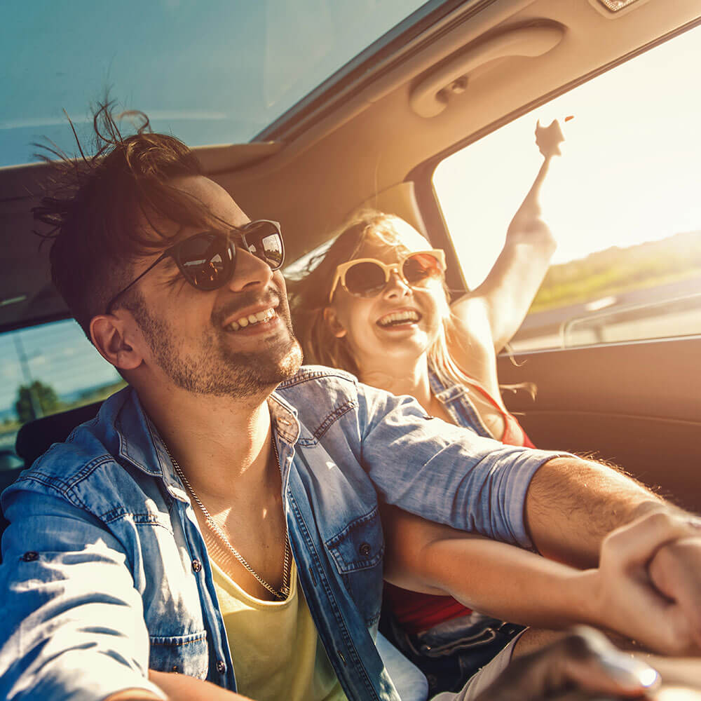 People smiling in the backseat of a car