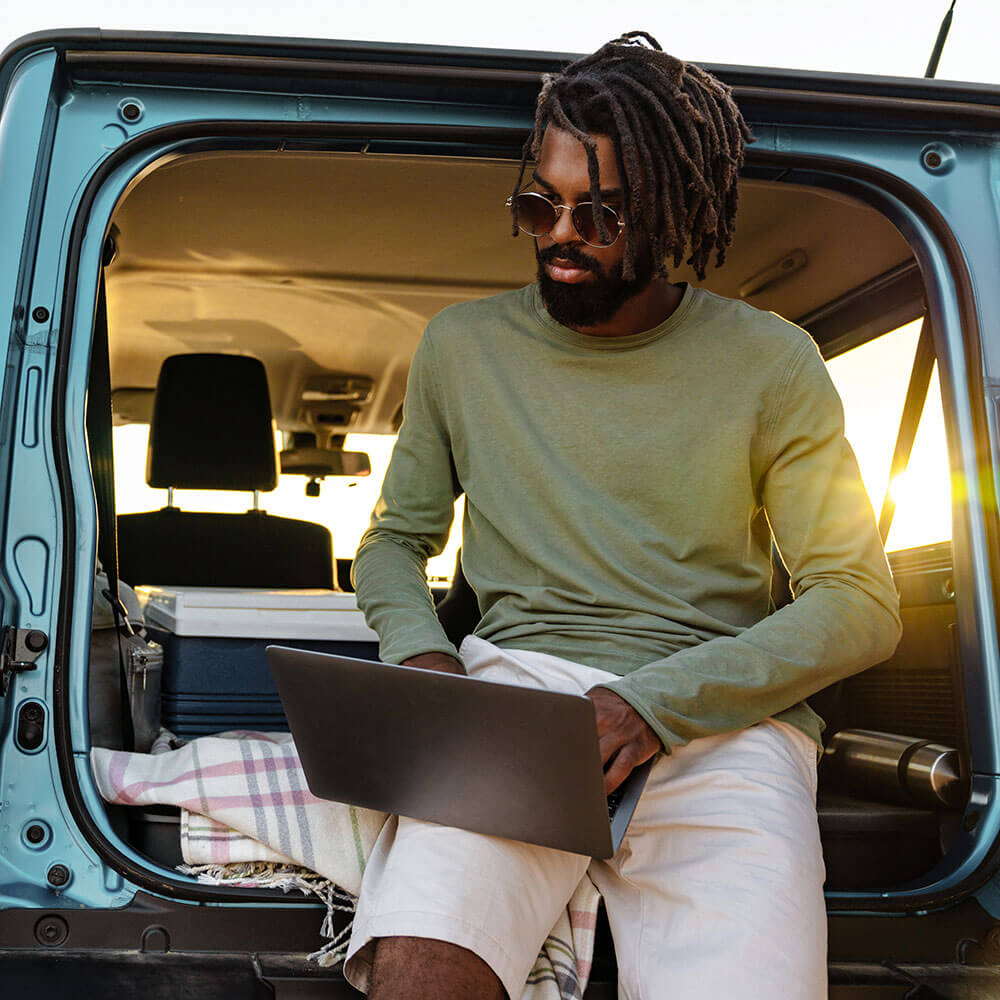 Man using a laptop in a car