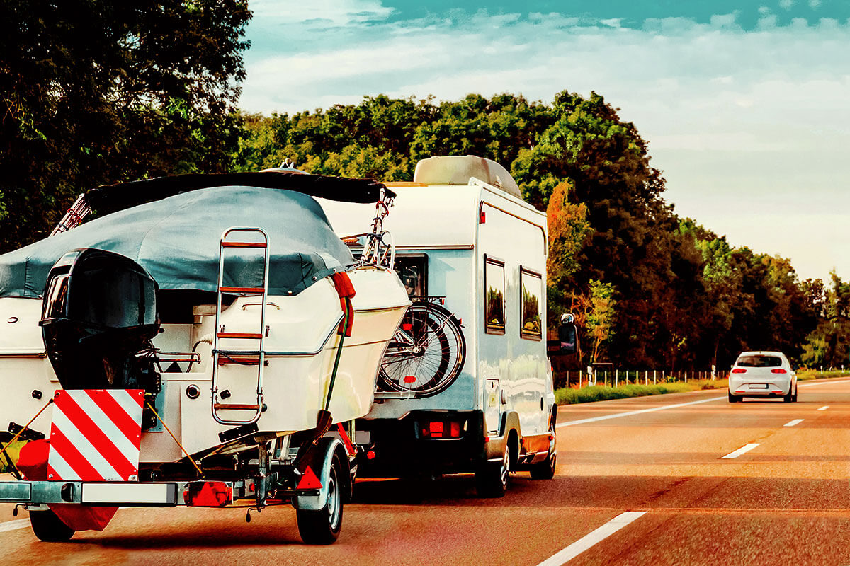 RV towing a boat down the road