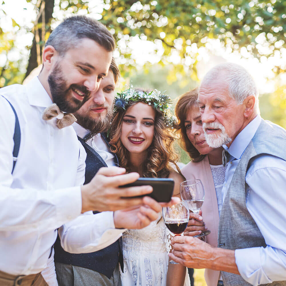 People looking at a phone at a wedding